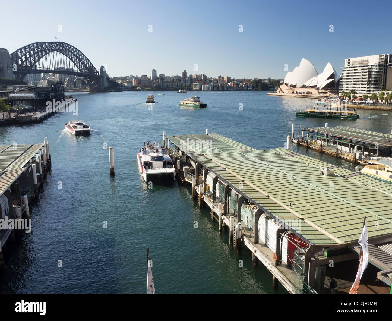 Le Circular Quay compte les quais 6, 5 et 4 sur Sydney Cove, avec des ferries pour le port, le Harbour Bridge et l'opéra en arrière-plan. Banque D'Images