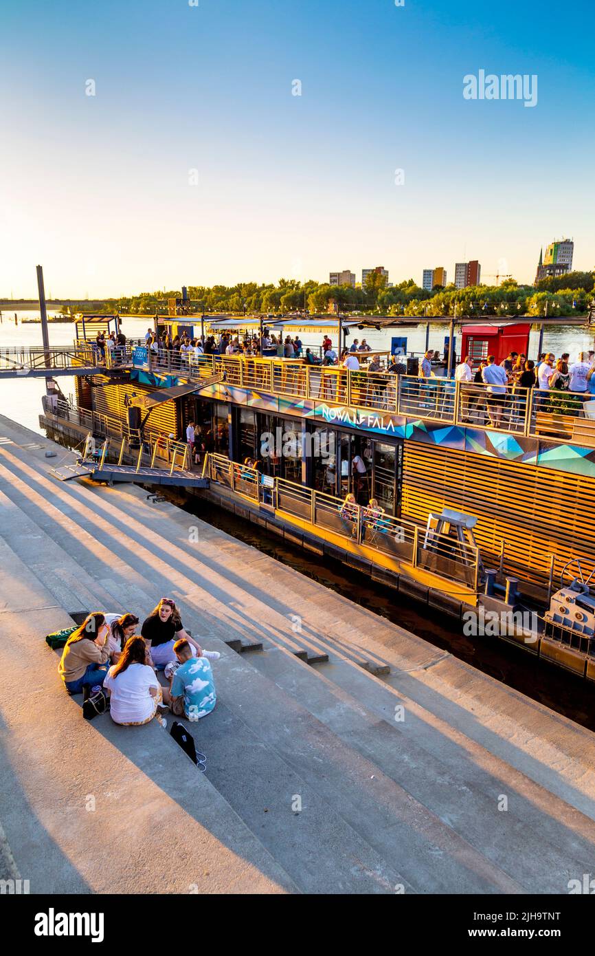 Les gens qui profitent d'une chaude journée d'été au coucher du soleil au bar et restaurant Nowa Fala Barge sur la Vistule, Powisle, Varsovie, Pologne Banque D'Images Les gens qui profitent d'une chaude journée d'été au coucher du soleil au bar et restaurant Nowa Fala Barge sur la Vistule, Powisle, Varsovie, Pologne Banque D'Images