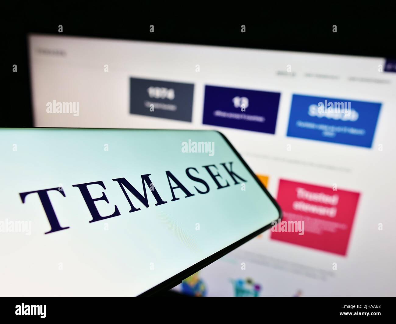 Smartphone avec le logo de la société Temasek Holdings Private Limited à l'écran devant le site Web d'affaires. Concentrez-vous sur le centre de l'écran du téléphone. Banque D'Images