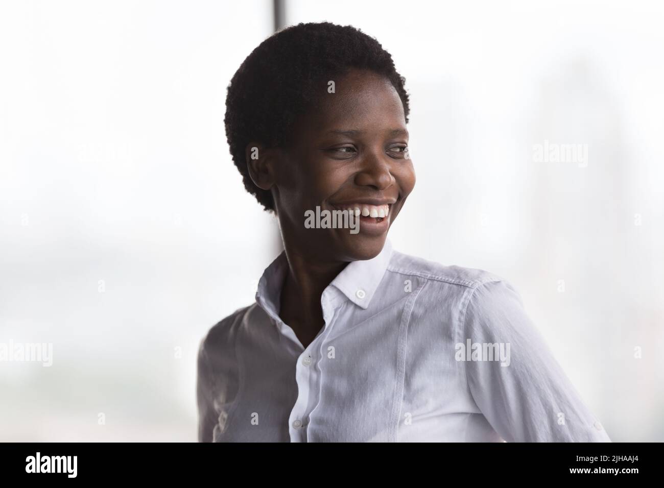 Bonne joyeuse femme d'affaires afro-américaine regardant loin Banque D'Images