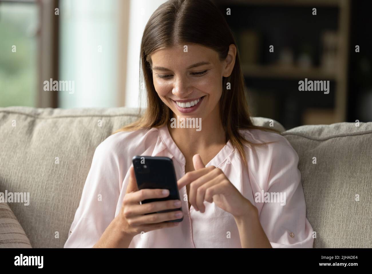 Gros plan jeune femme magnifique utilisant un smartphone à la maison Banque D'Images