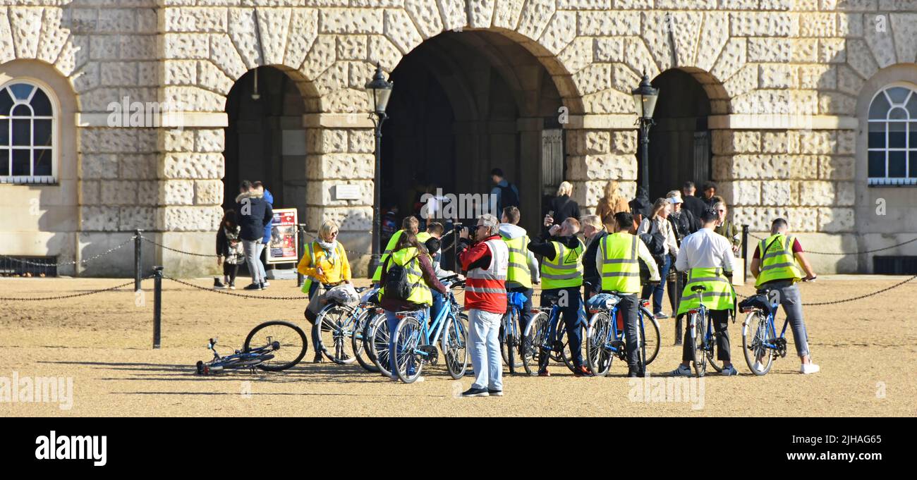 Groupe de touristes sur la visite en vélo portant des vestes haute visibilité au terrain historique Horse Guards Parade pour un arrêt photo Londres Angleterre Royaume-Uni Banque D'Images