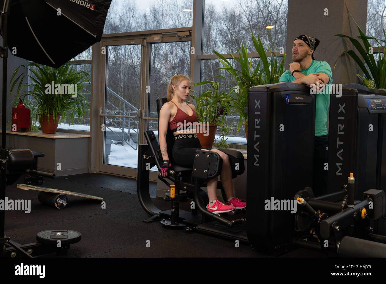RUSSIE, MOSCOU - 11 FÉVRIER 2022: L'entraînement dirigé par un instructeur aide un beau client à effectuer des exercices dans un club de fitness, le concept de jouer du sport Banque D'Images