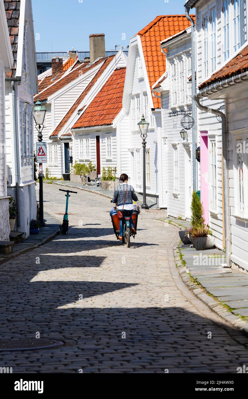 Femme sur poussette avec enfant manèges de pannier passé traditionnel, blanc, bois peint maisons norvégiennes sur øvre Strandgate, Stavanger, Norvège. Banque D'Images