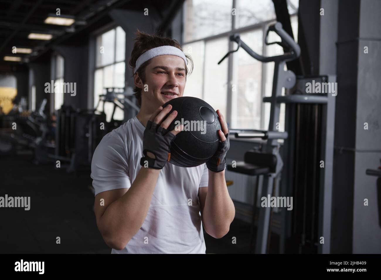 Beau homme de forme physique heureux entraînement avec Medicine ball au studio de sport Banque D'Images