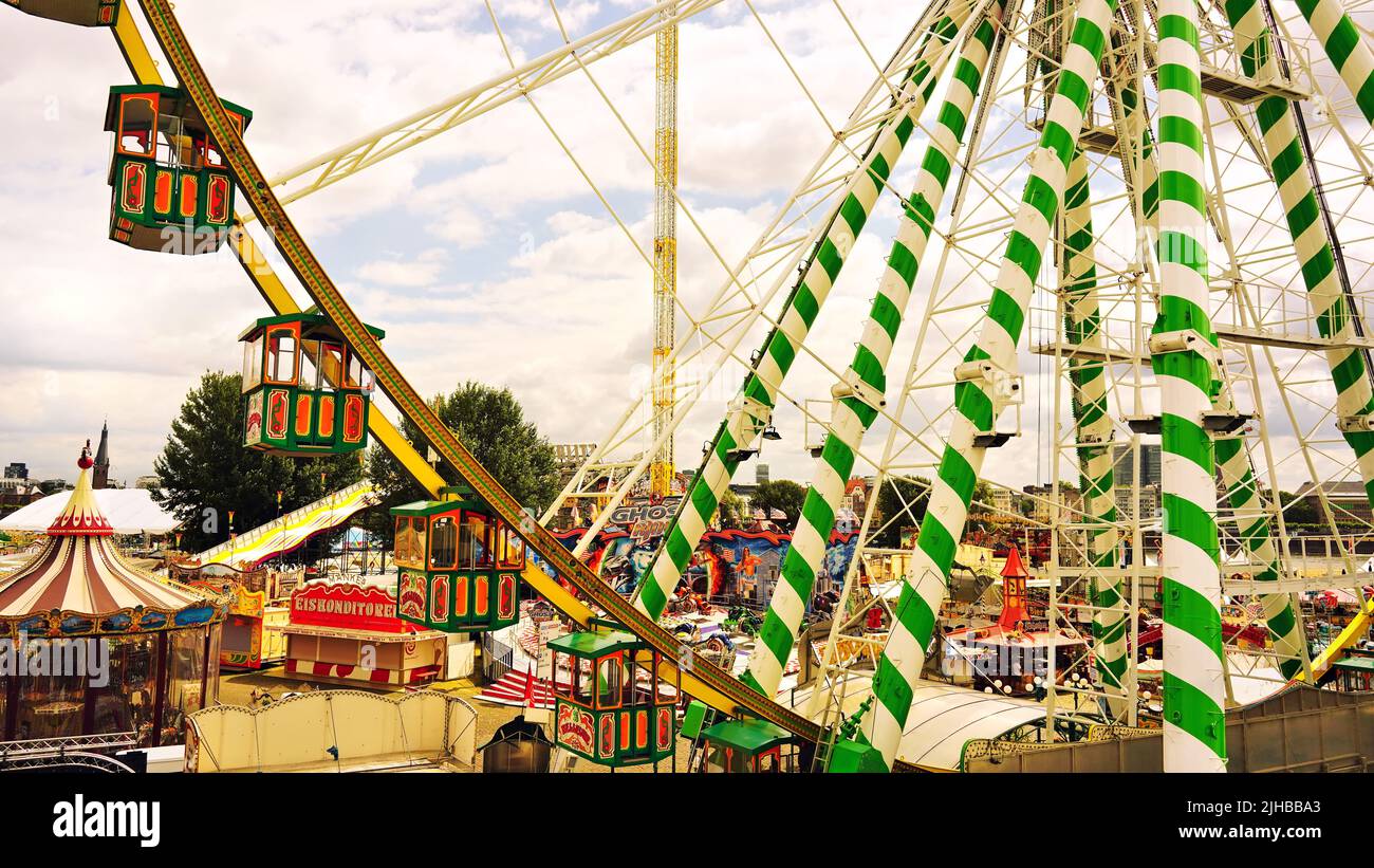 Vue sur la célèbre foire d'amusement 'Rheinkirmes' 2022 à Düsseldorf/Allemagne, la plus grande foire d'amusement sur le Rhin, avec la roue de ferris en premier plan. Banque D'Images