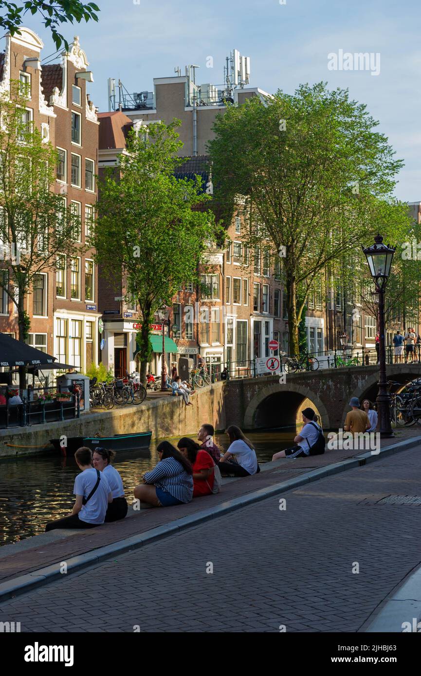 Détente au bord du canal au coucher du soleil à Amsterdam Banque D'Images