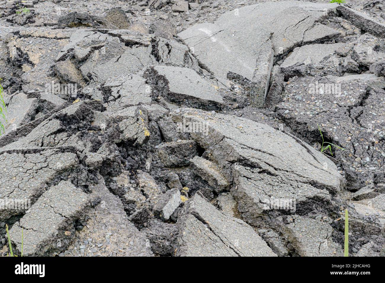 Une pile d'asphalte décoloré et cassé qui a été retirée d'une route pour pouvoir être repavée. Concentrez-vous sur l'asphalte de plus près. Banque D'Images