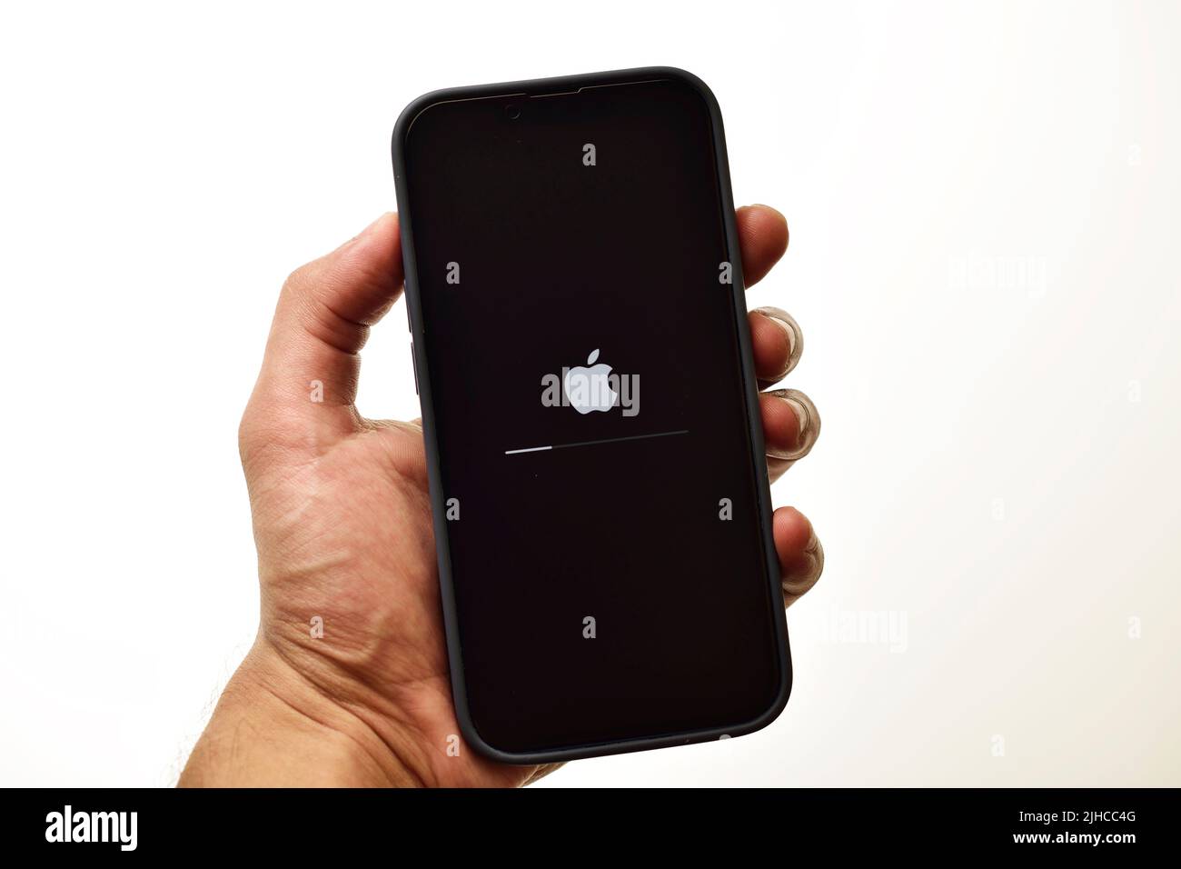 New Delhi, Inde - 8 juillet 2022 : tenez l'iPhone avec le processus de mise à jour du firmware iOS à l'écran Banque D'Images