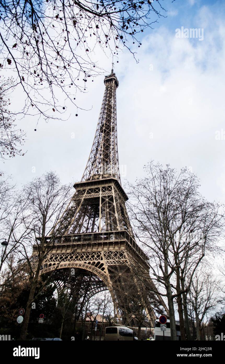 Photo verticale en petit angle de la tour Eiffel entourée d'arbres sans feuilles Banque D'Images