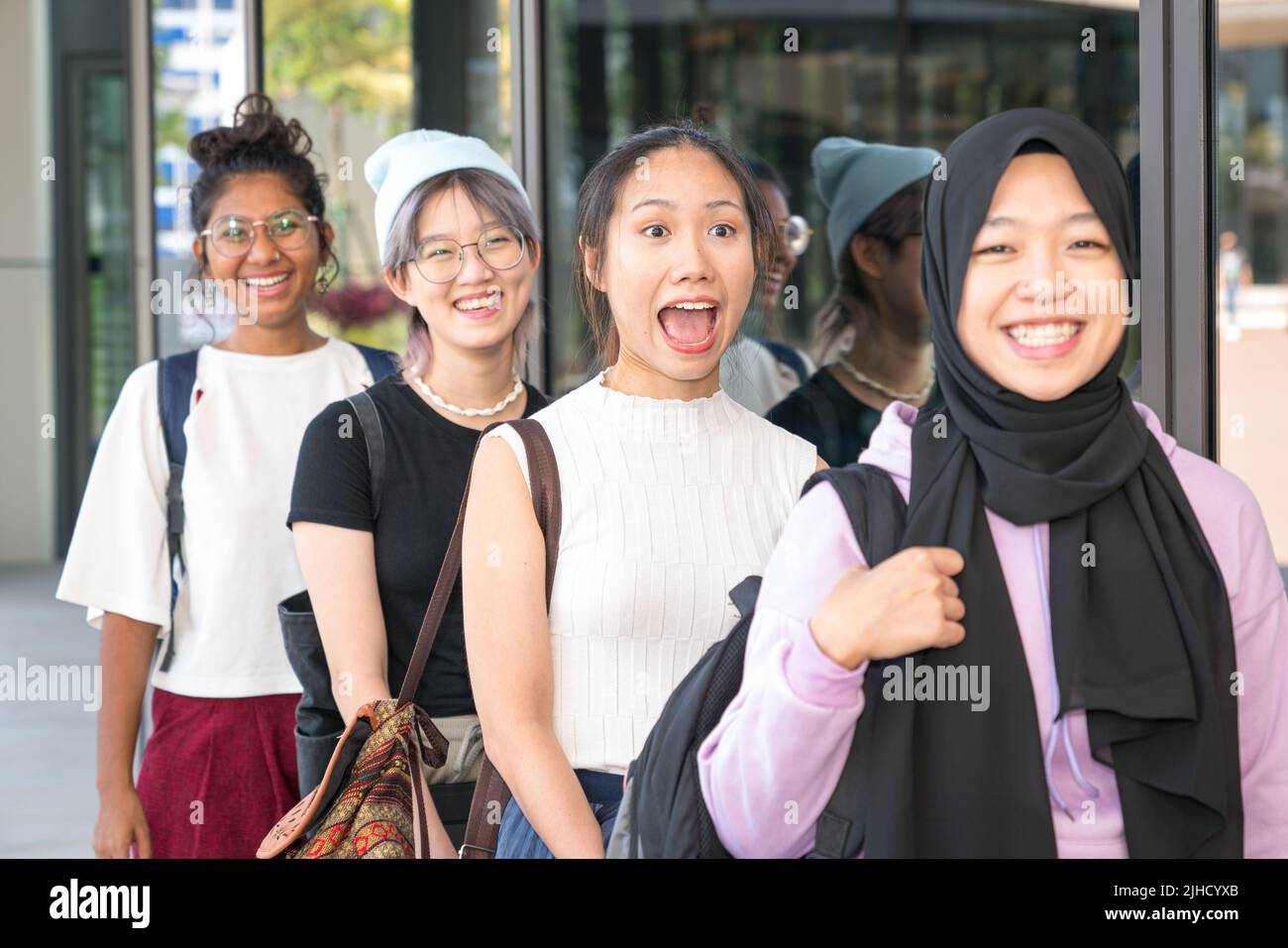 Groupe de jeunes femmes multiethniques heureuses debout dans une rangée. Mise au point sélectionnée. Banque D'Images