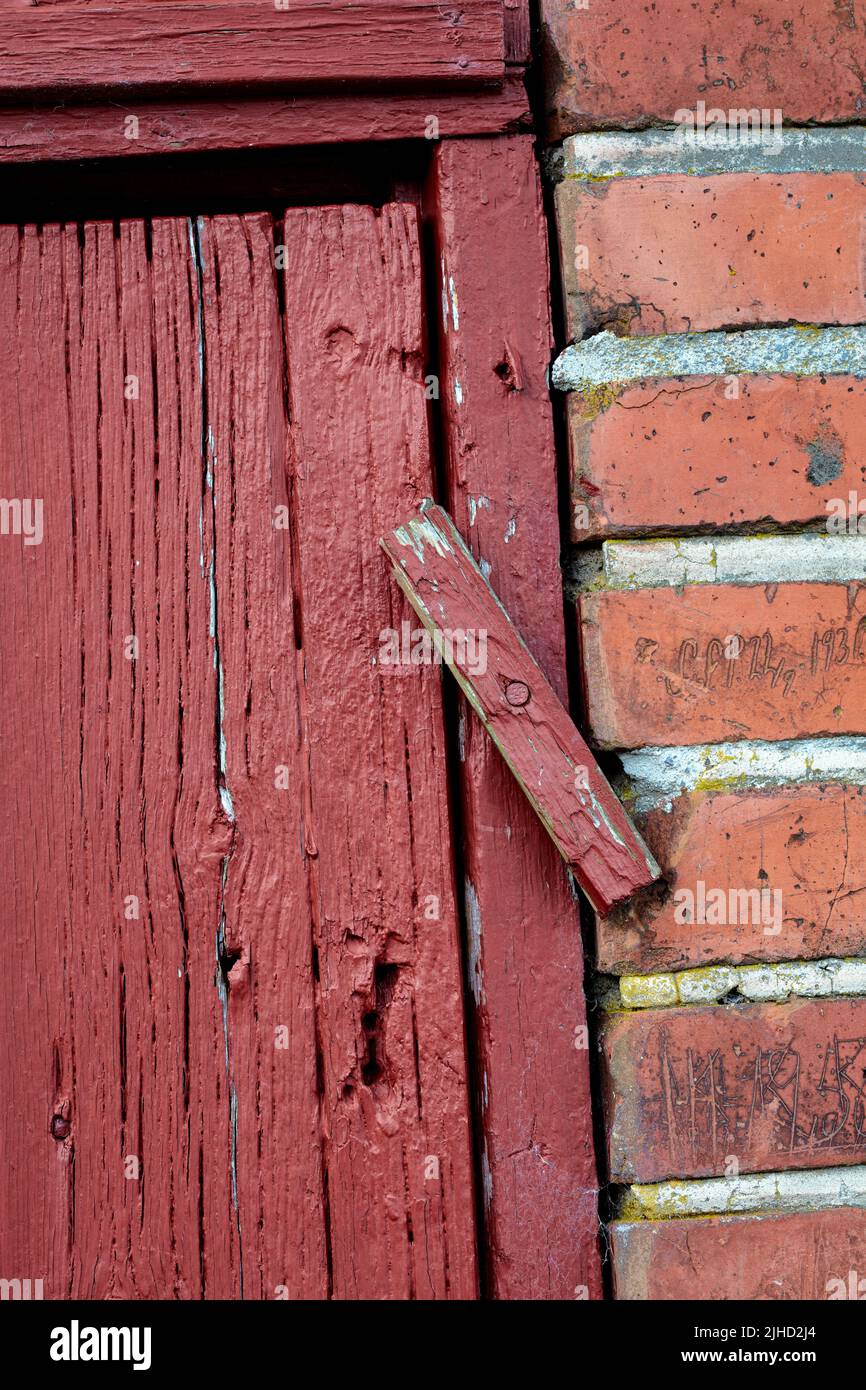 Portes. Gros plan d'une ancienne porte en bois rouge dans un bâtiment en briques de face, probablement une maison dans un quartier résidentiel. Un verrou de verrouillage sur une entrée. Banque D'Images