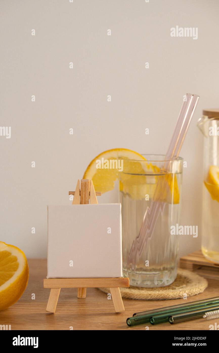 Toile de peinture vide pour vous texte maquette espace copie verre d'eau avec jus de citron frais avec pailles en verre réutilisables Detox eau tonique froide avec tranches de citron ensoleillées mode de vie peu de déchets mode de vie Eco-friendly Drinking Straw Set avec brosse de nettoyage. Concept sans déchets, sans plastique Banque D'Images