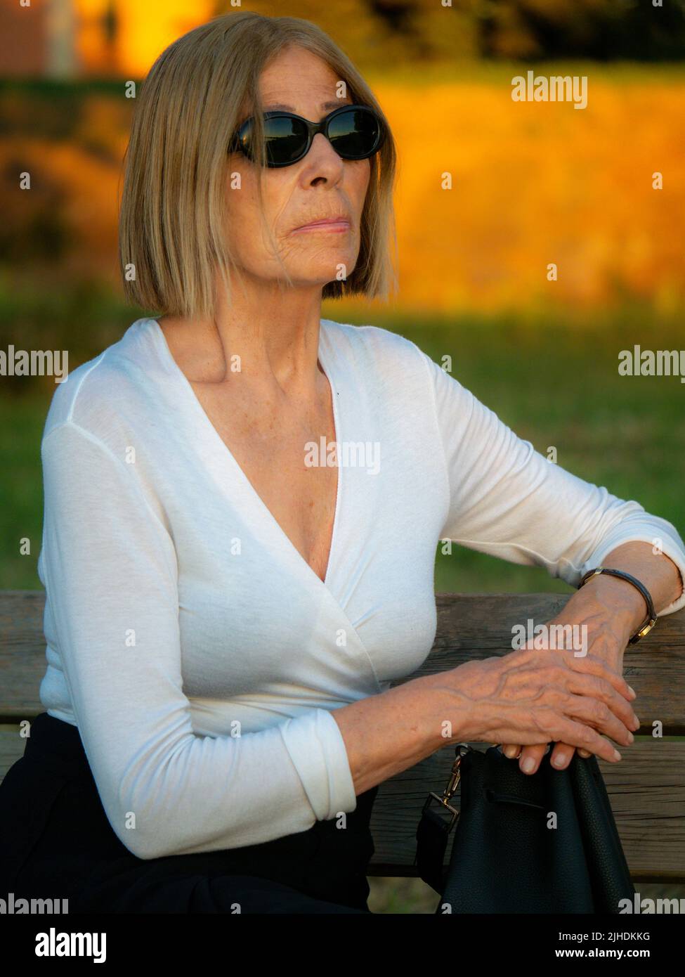 senior tenue élégante dame habillé blaka dn blanc portant des lunettes de soleil appréciant la nature en été Banque D'Images