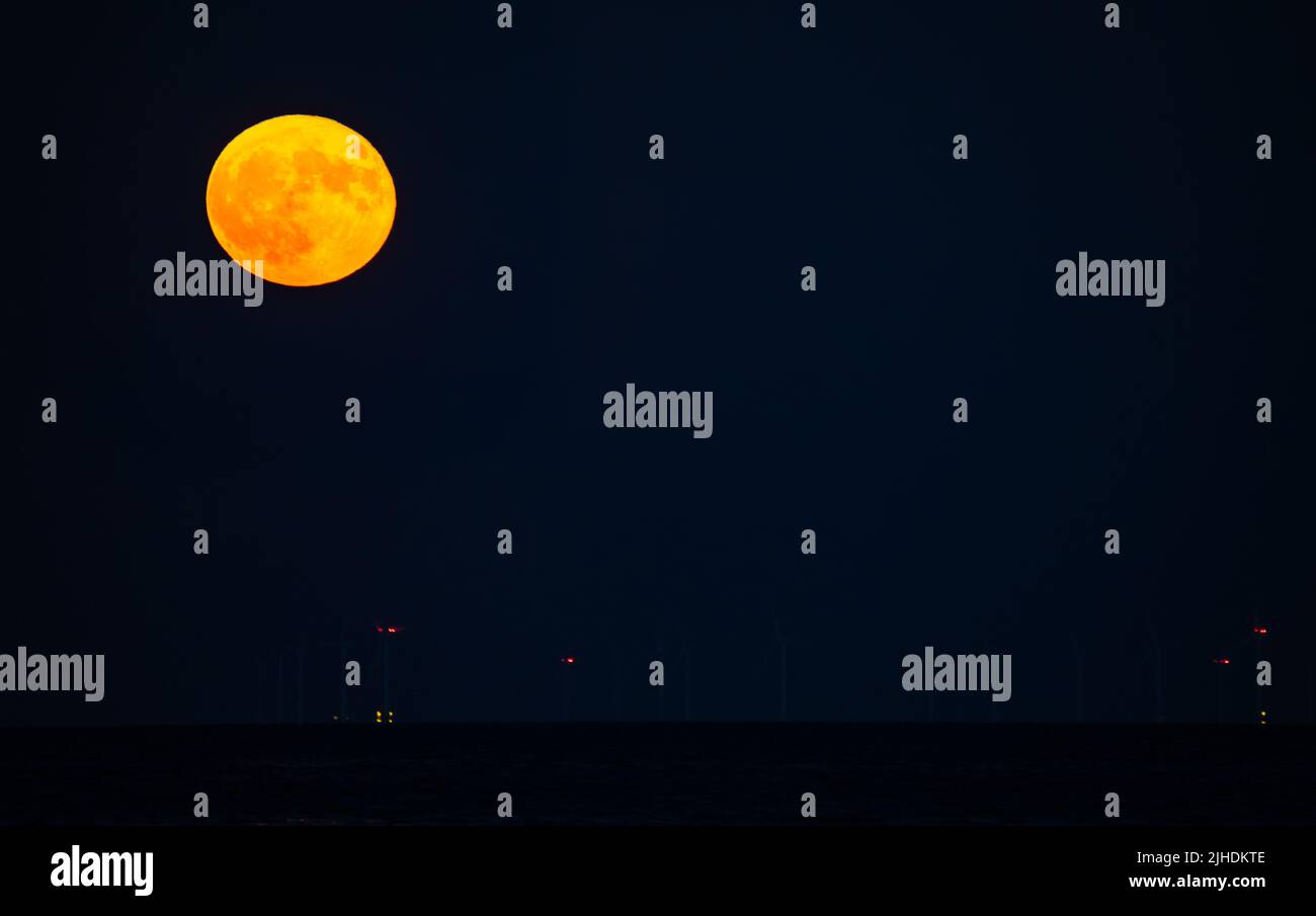 Pleine lune orange dans le ciel nocturne. Banque D'Images