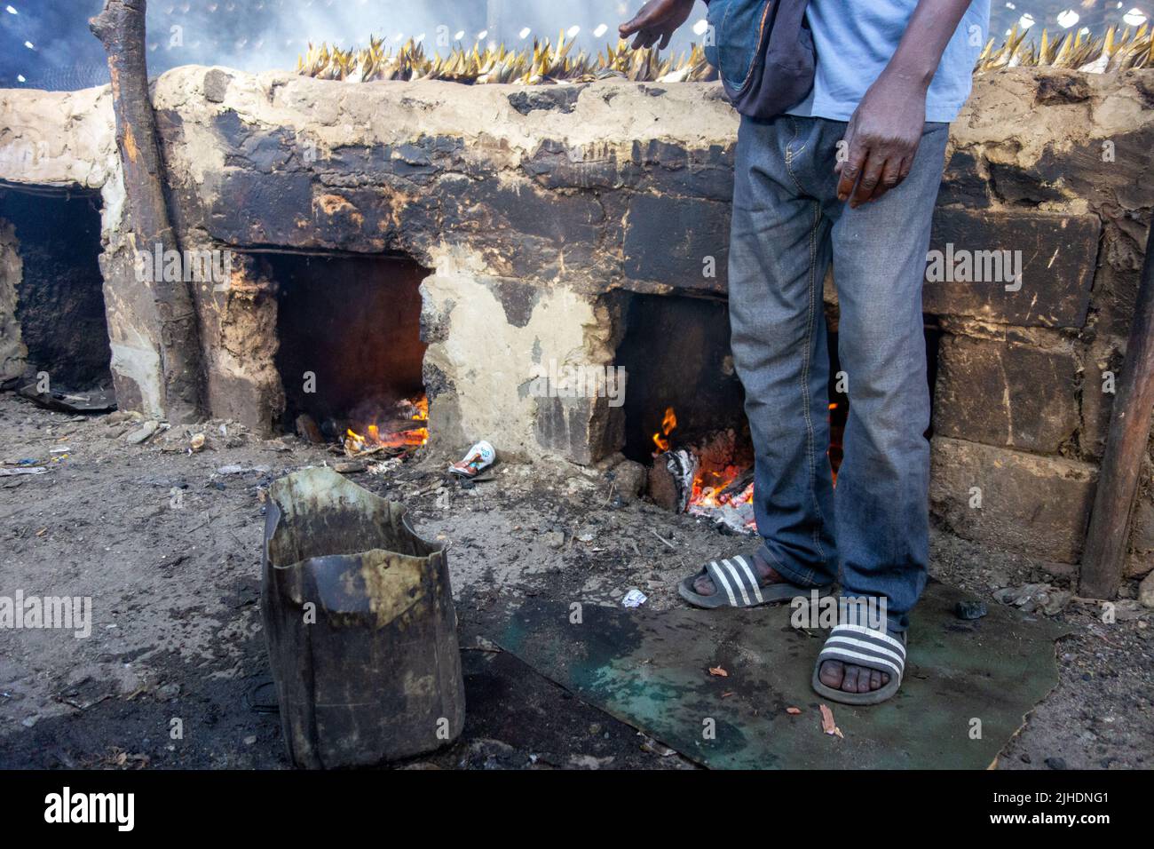 TANJI, GAMBIE - 6 FÉVRIER 2022 incendies dans un fumoir traditionnel pour fumer du poisson de bonga (Ethmolosa fimbriata) pêché frais en Gambie Banque D'Images