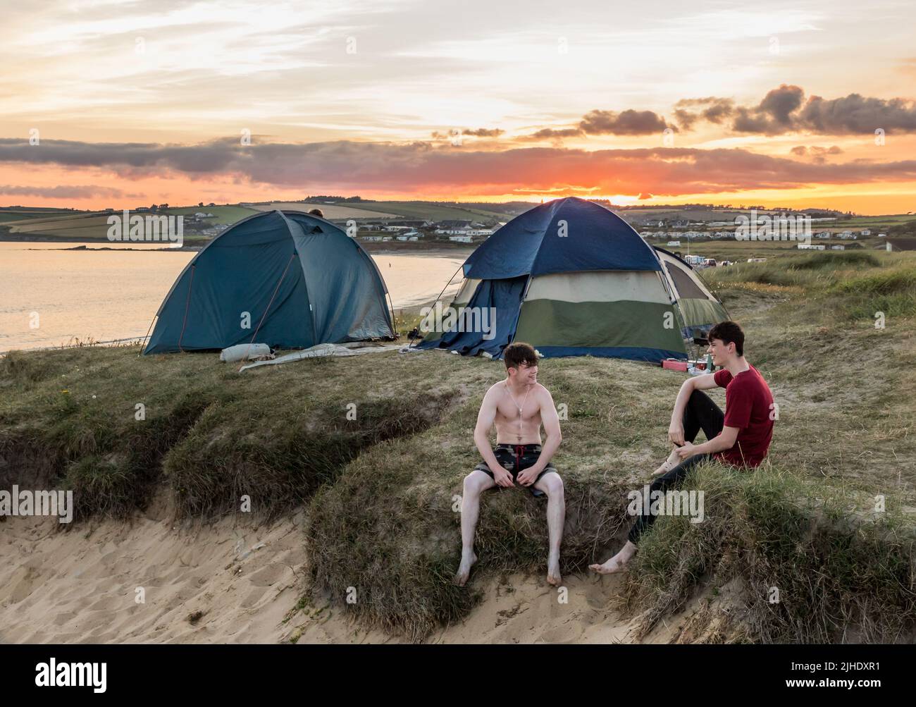 Garrylucas, Cork, Irlande. 17th juillet 2022. Au cours d'une chaude soirée d'été, les campeurs Joseph Lawlor de Kinsale et Willie Burke de Cobh se détendent sur les dunes de sable tandis que le soleil se couche à Garrylucas, Co. Cork, Irlande. - Crédit; David Creedon / Alamy Live News Banque D'Images