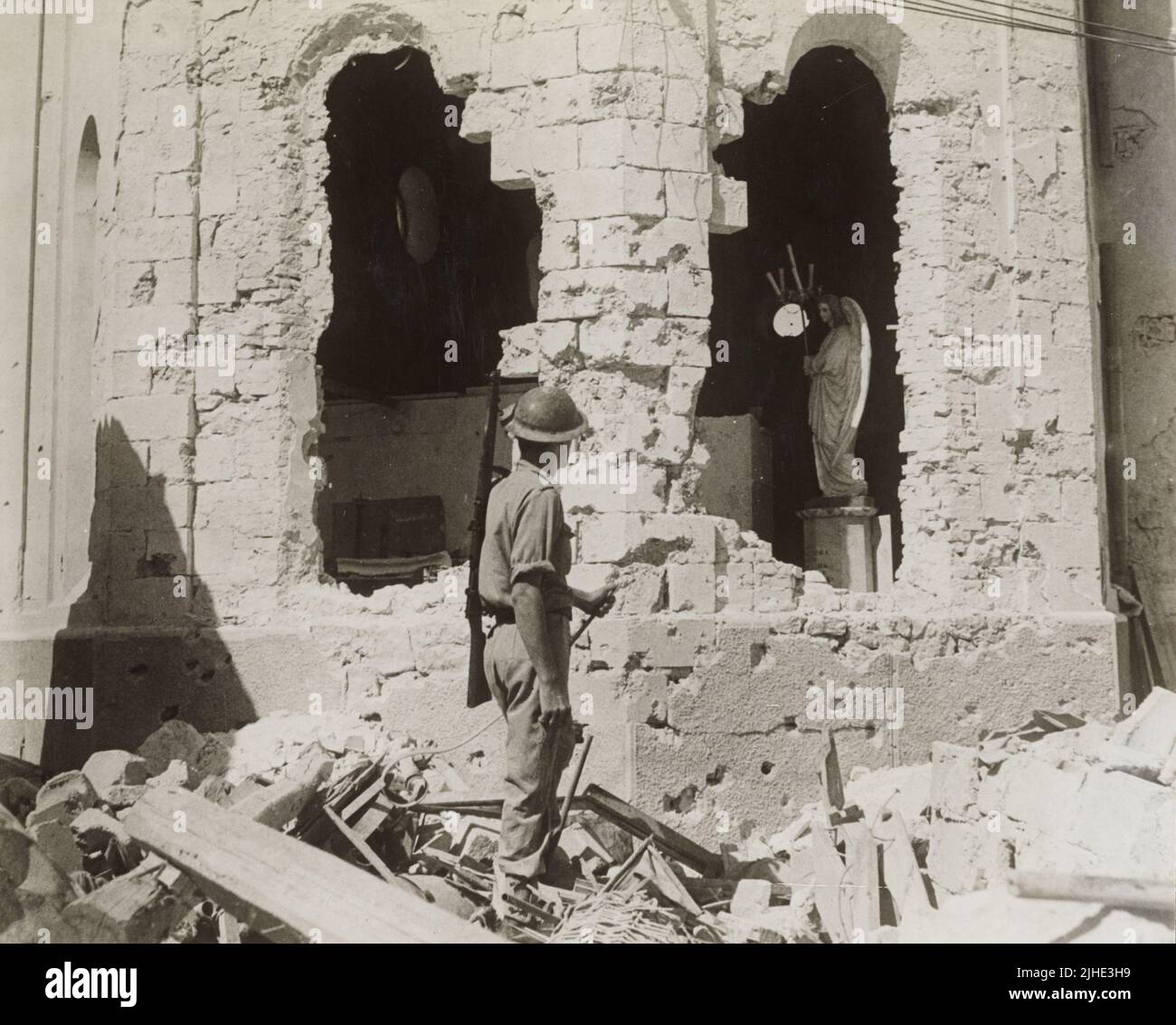 Une photo d'époque datée de 9 décembre 1941 montrant un soldat britannique regardant la bombe a endommagé les ruines d'une église catholique après le siège de Tobruk Libye en Afrique du Nord pendant la deuxième guerre mondiale Banque D'Images