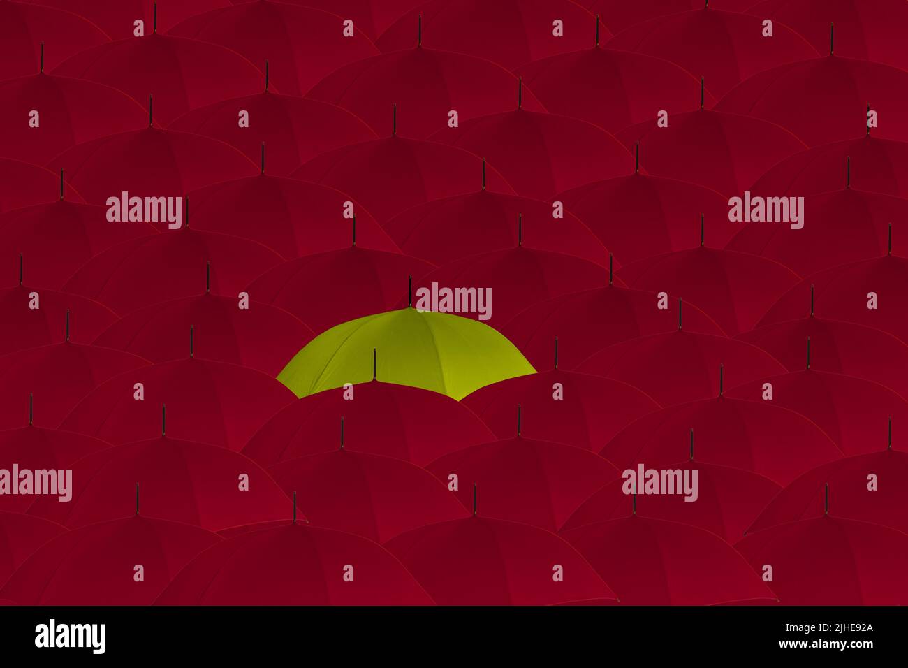 démarquez-vous de la foule étrange une foule hors concept de parasols rouges un parapluie jaune se démarquant Banque D'Images