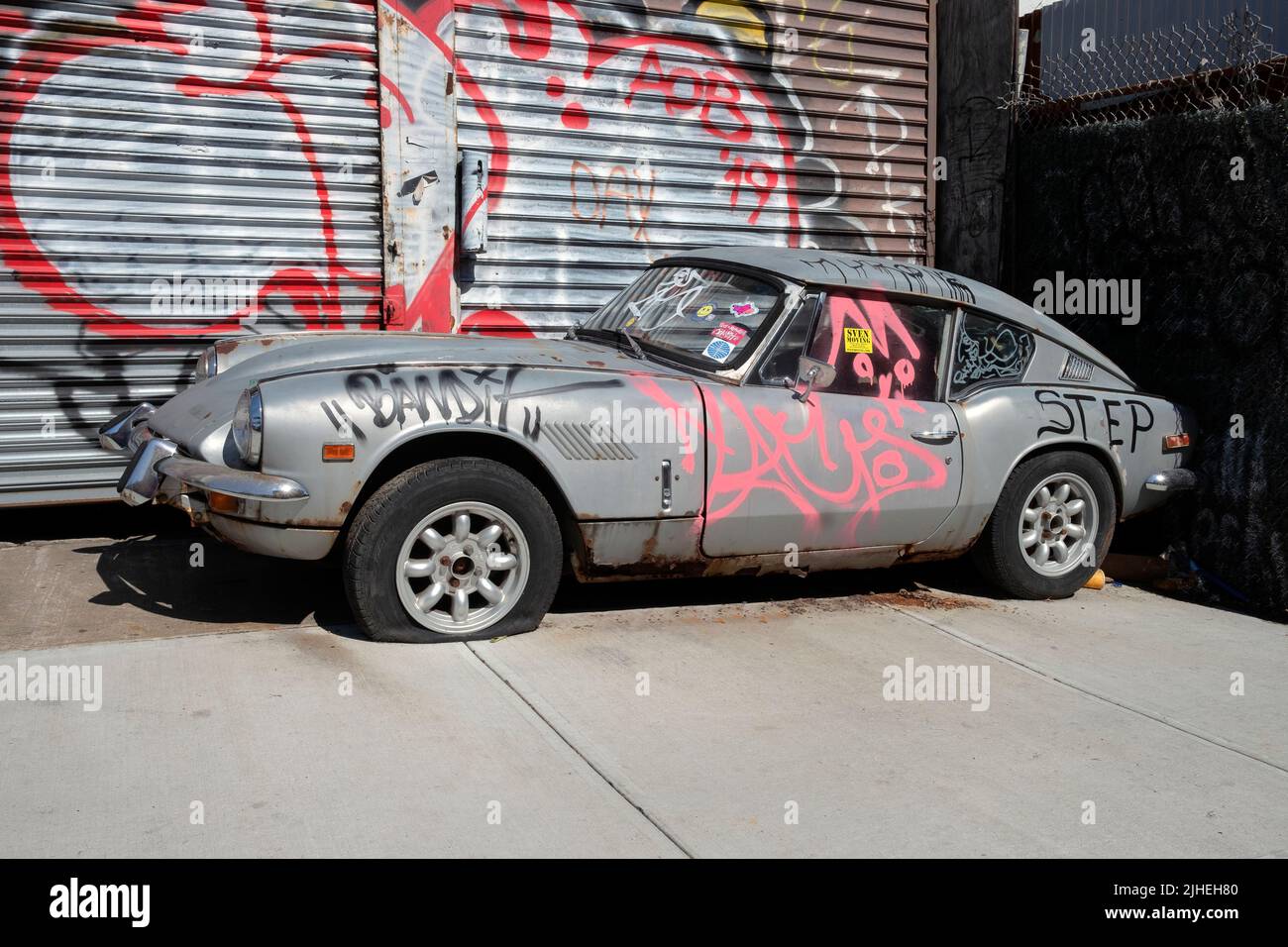 PAYSAGE URBAIN. Une berline Jaguar à graffitiée et ratée sur Roebling Street à Williamsburg, Brooklyn, New York. Banque D'Images