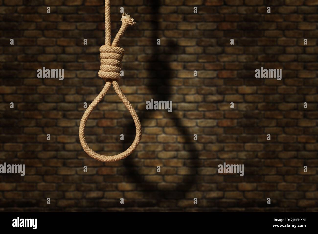 suicide concept. noose avec ombre sur fond de mur sombre Banque D'Images