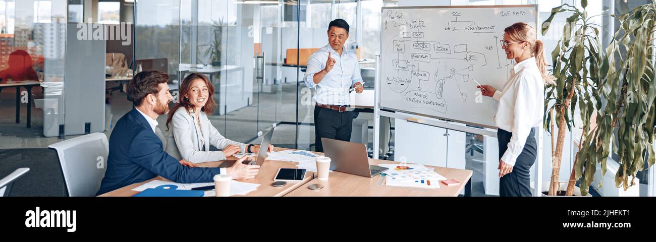 L'homme et la femme asiatiques tiennent une réunion pour les employés près d'un tableau de conférence et expliquent la stratégie de travail Banque D'Images
