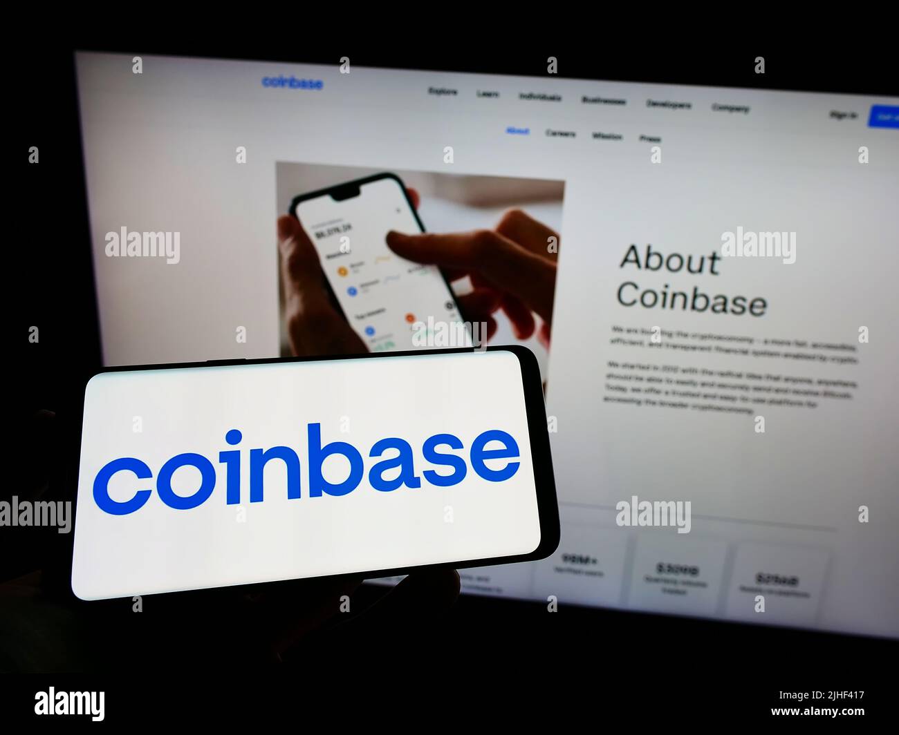 Personne tenant un téléphone mobile avec le logo de la société américaine d'échange de crypto Coinbase Global Inc. À l'écran en face de la page Web. Mise au point sur l'affichage du téléphone. Banque D'Images