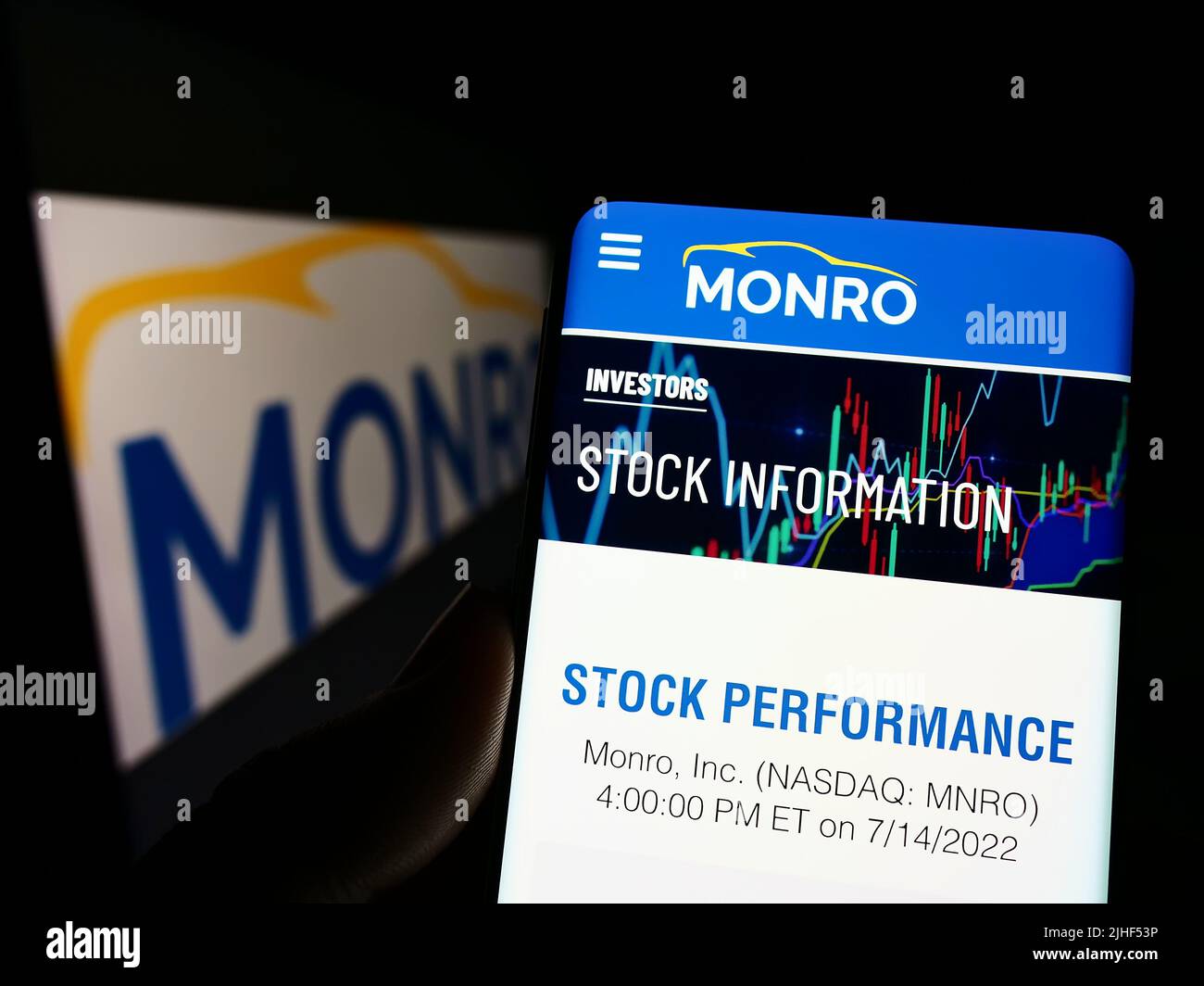 Personne tenant un smartphone avec la page Web de la société de service automobile américaine Monro Inc. À l'écran devant le logo. Concentrez-vous sur le centre de l'écran du téléphone. Banque D'Images