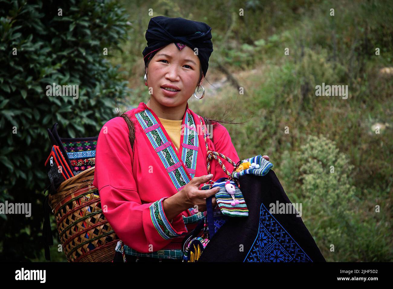 Une jeune femme de Zhuang offrant des souverneurs tricotés à Ping'an, Longsheng, Chine. Banque D'Images
