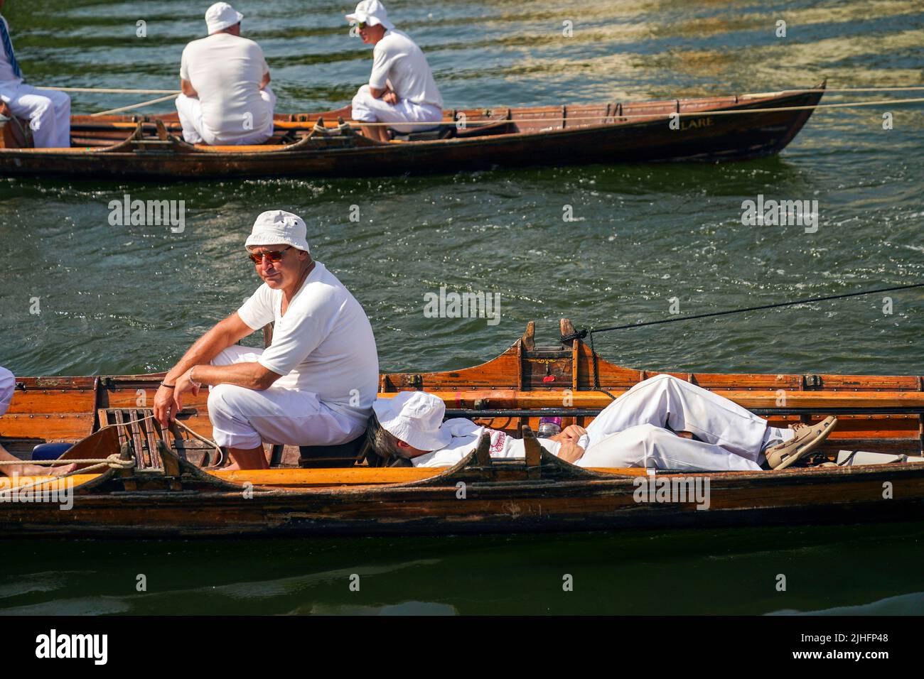 Les cygnes sont tirés le long d'un bateau près de Chertsey dans le Surrey, pendant l'ancienne tradition du cygne en amont, le recensement annuel de la population de cygnes sur la Tamise. Date de la photo: Lundi 18 juillet 2022. Banque D'Images