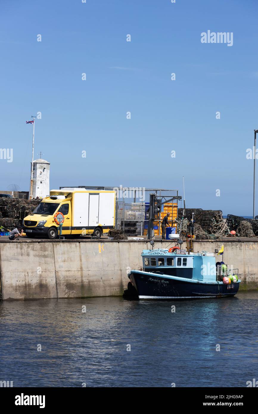 Bateau de pêche déchargeant ses prises au port de Seahouses, Northumberland, Angleterre. Banque D'Images