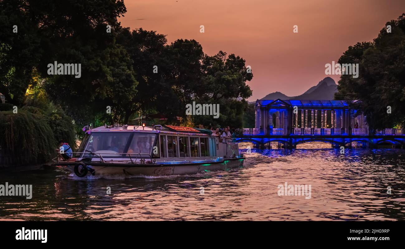 Guilin, Chine - août 2019 : croisière touristique en bateau ferry transportant des touristes naviguant devant le pont en verre de Crystal sur le lac Shan, ville de Guilin, Gu Banque D'Images