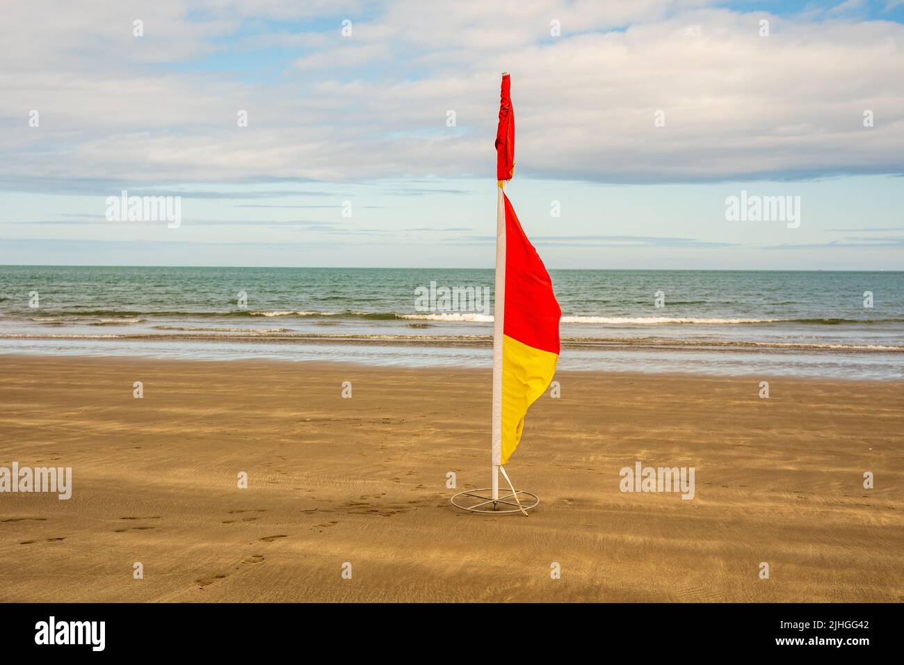 drapeau rouge et jaune isolé sur une plage Banque D'Images