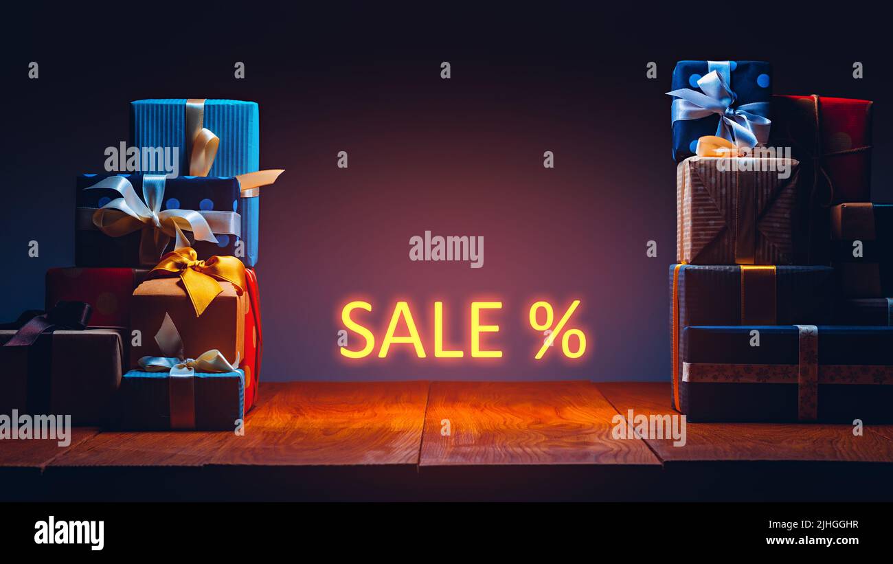 Boîtes-cadeaux sur la table avec éclairage au néon. Concept de vente Banque D'Images