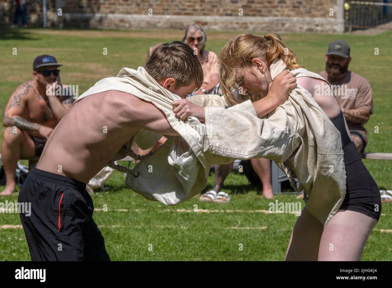 Une adolescente en compétition contre un adolescent dans le Grand Cornish Wrestling Tournament pittoresque village vert de St Mawgan à Pydar en Cornouailles. Banque D'Images