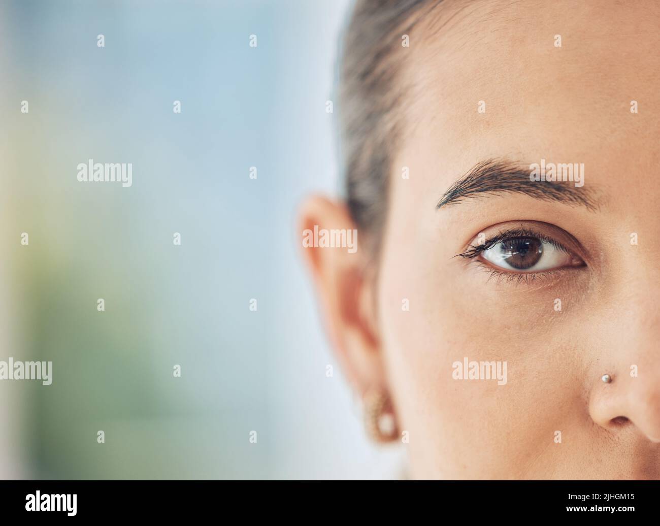 Gros plan d'une femme de race mixte, à moitié face, avec un nez piquant regardant directement la caméra. Belle jeune femme multi-ethnique tête de regarder Banque D'Images
