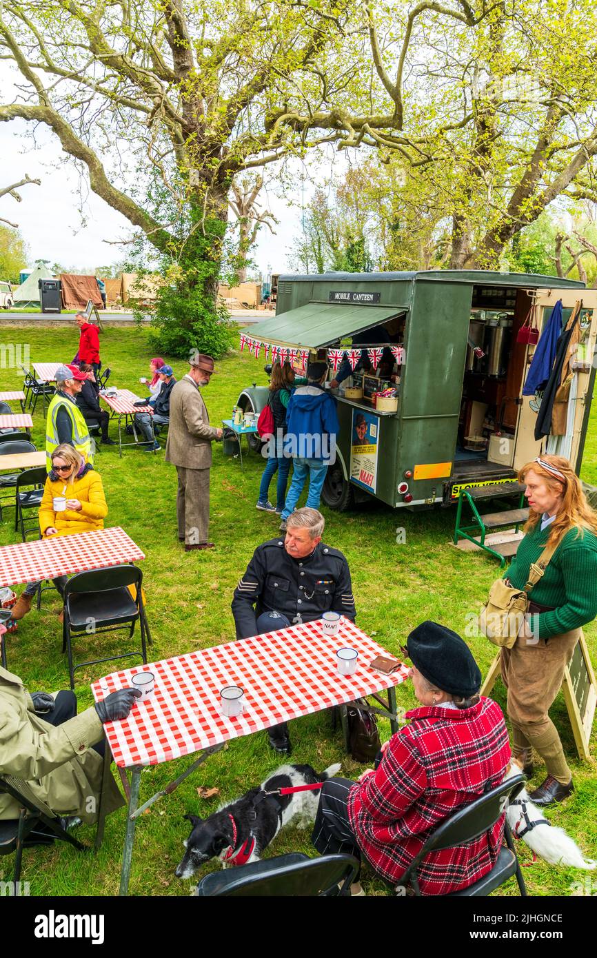 Deuxième guerre mondiale NAAFI mobile Canteen i n un parc, avec des personnes en manteaux assis autour de tables pendant un 'salute à l'événement des années 40 '. Banque D'Images