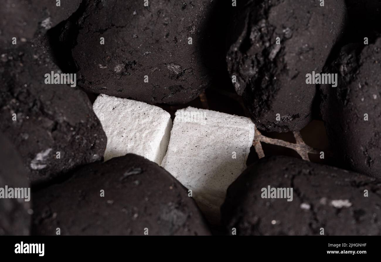 Allumer un feu de barbecue. Briquette et briquette blanche. Flamme au charbon de bois. Banque D'Images