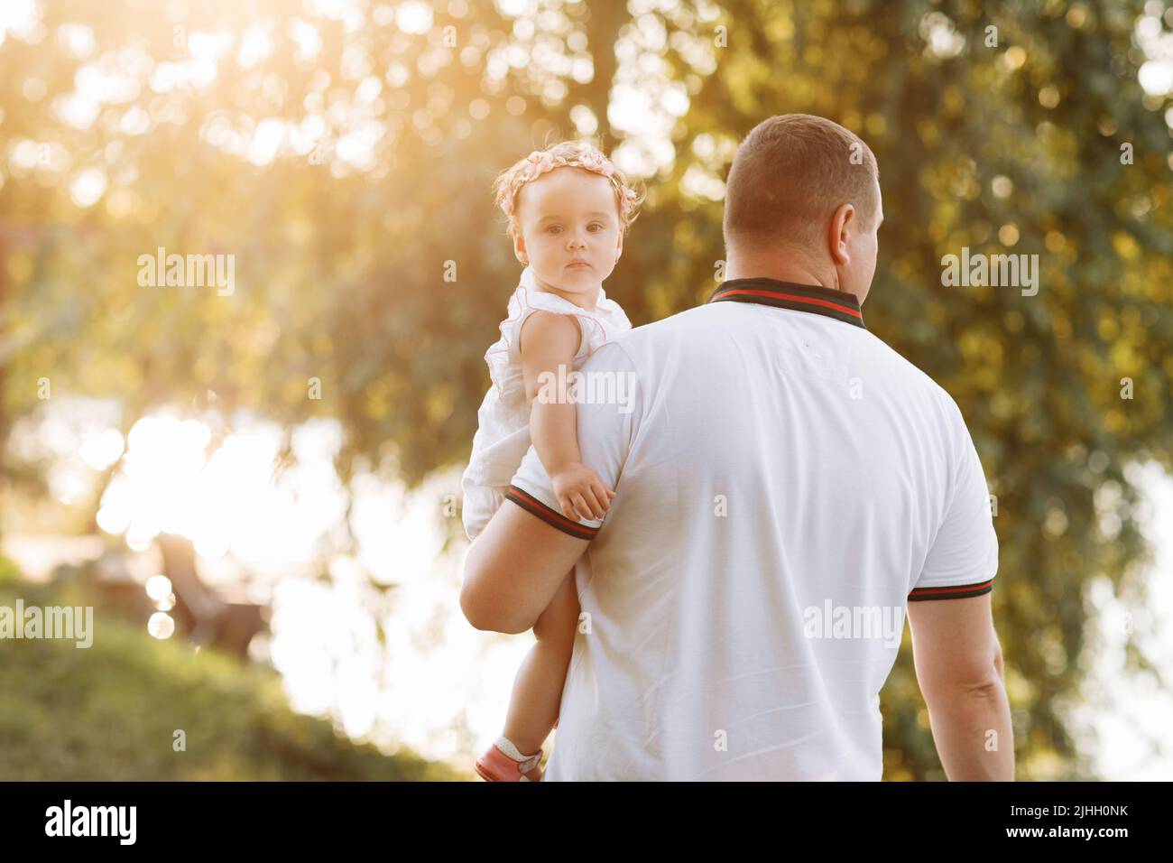 fête des pères. Un père souriant embrasse sa petite fille dans le parc vert. Le concept de vacances d'été. Famille passant du temps ensemble sur natur Banque D'Images