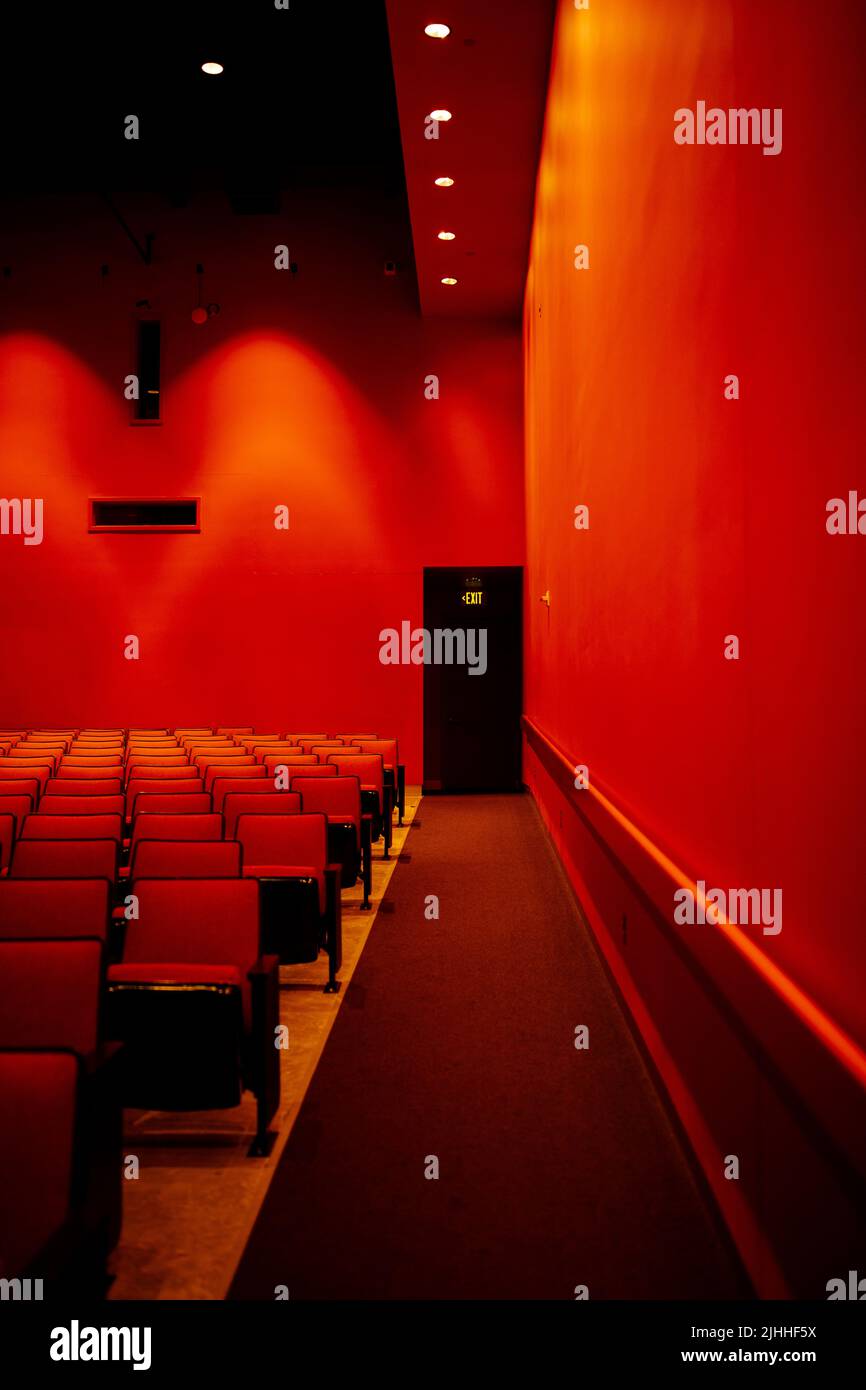 auditorium rouge vif avec sièges recouverts de tissu et panneau de sortie Banque D'Images