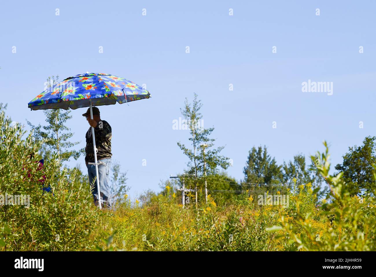 Homme tenant un parasol pendant une journée chaude Banque D'Images