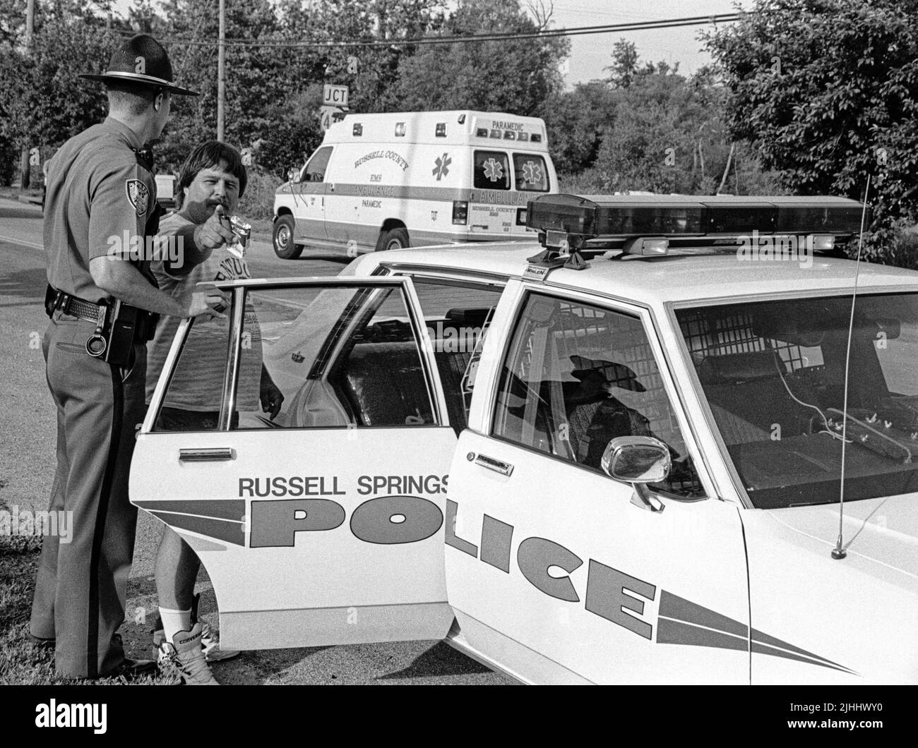 Troy Scott Stephens, 32 ans, du 2710 E. Hwy. 619 (à droite), tente et ne parvient pas à intimider un photographe de presse alors que le Patrolman Daniel Garland le place en détention suite à un incident présumé de violence domestique lundi, 3 juin 1996 à Russell Springs, comté de Russell, KY, États-Unis. Les accusations ont été plus tard rejetées, selon les dossiers du tribunal, mais Stephens a été arrêté à nouveau sur 13 juillet 1996 pour avoir prétendument agressé sa femme et une autre personne, puis a frappé plusieurs fois un shérif adjoint dans la tête avec une lampe de poche. (Photo APEX MediaWire par Billy Suratt) Banque D'Images