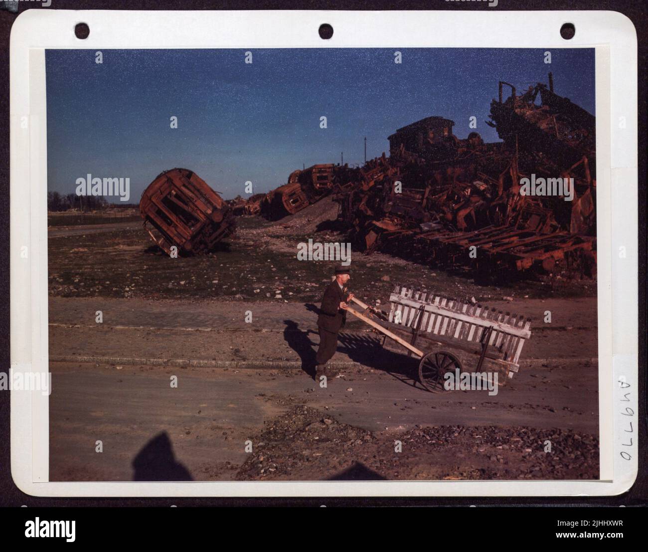 Les Allemands WAHO autrefois « High, Wide and Handsome » comme ils le disent au Texas, se promordent maintenant autour des ruines de voitures de chemin de fer tordues et tordues à Francfort, en Allemagne, en poussant un chariot vide. Banque D'Images