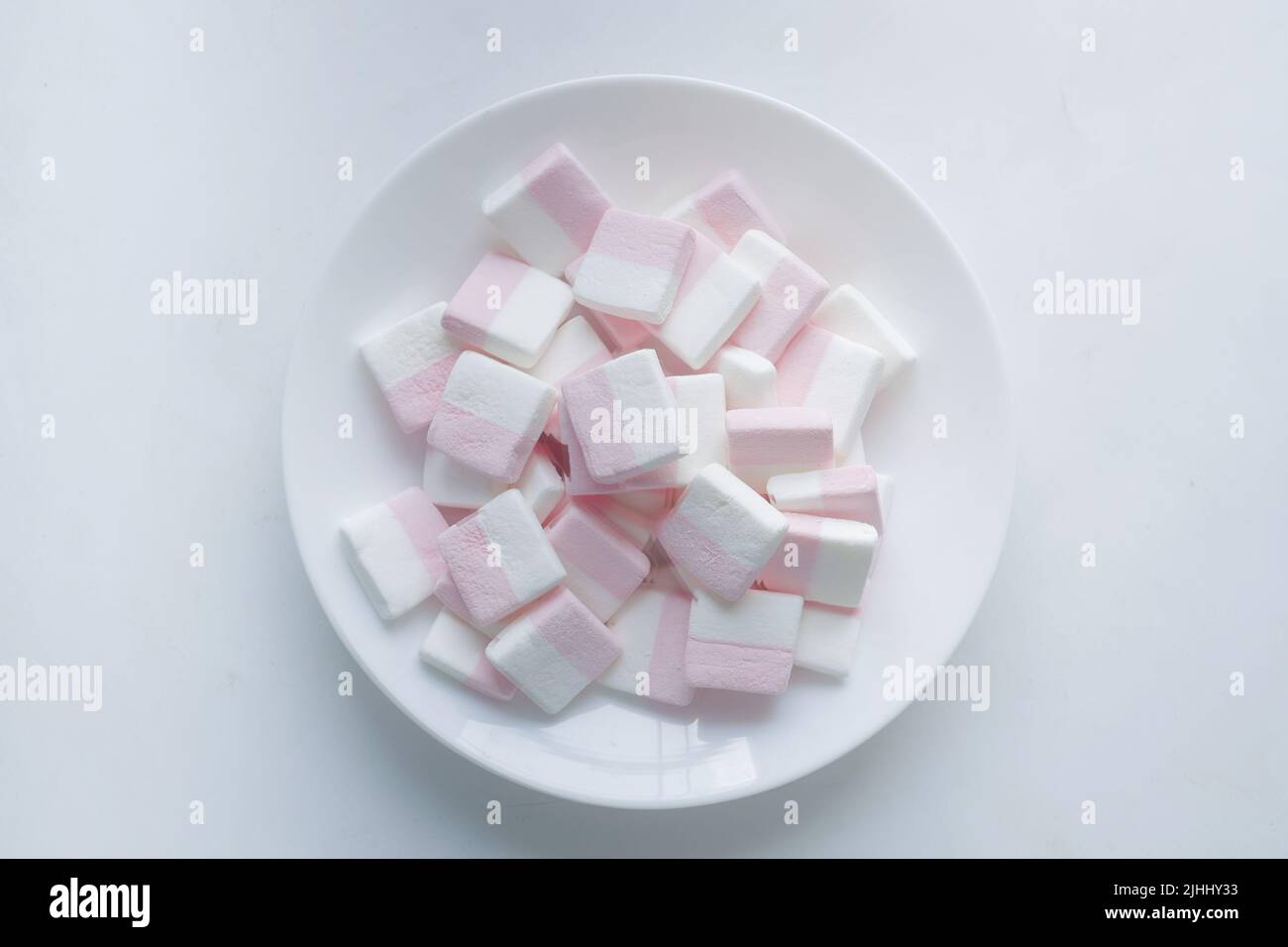 bonbon de guimauve dans un bol sur fond blanc Banque D'Images