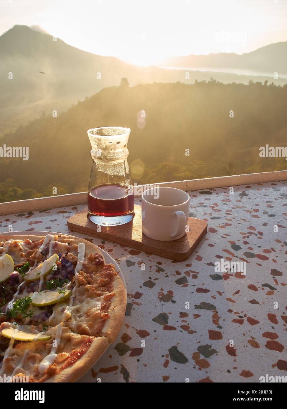 le menu du petit-déjeuner composé de pizzas et de cafés est servi sur la table avec un fond de lever du soleil Banque D'Images