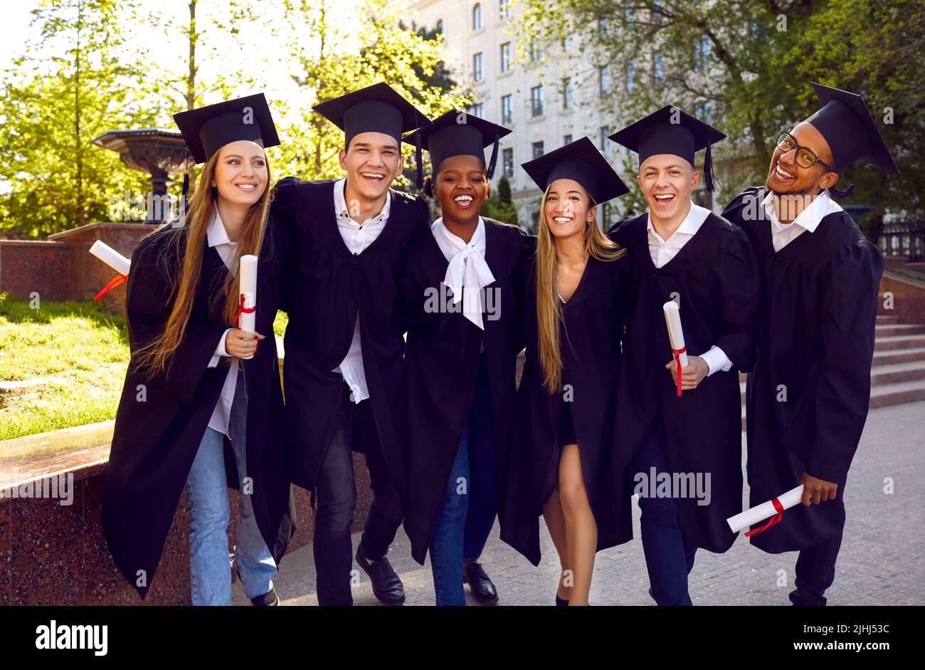 Portrait d'un groupe joyeux d'étudiants multiraciaux célébrant ensemble la journée de la remise des diplômes. Banque D'Images