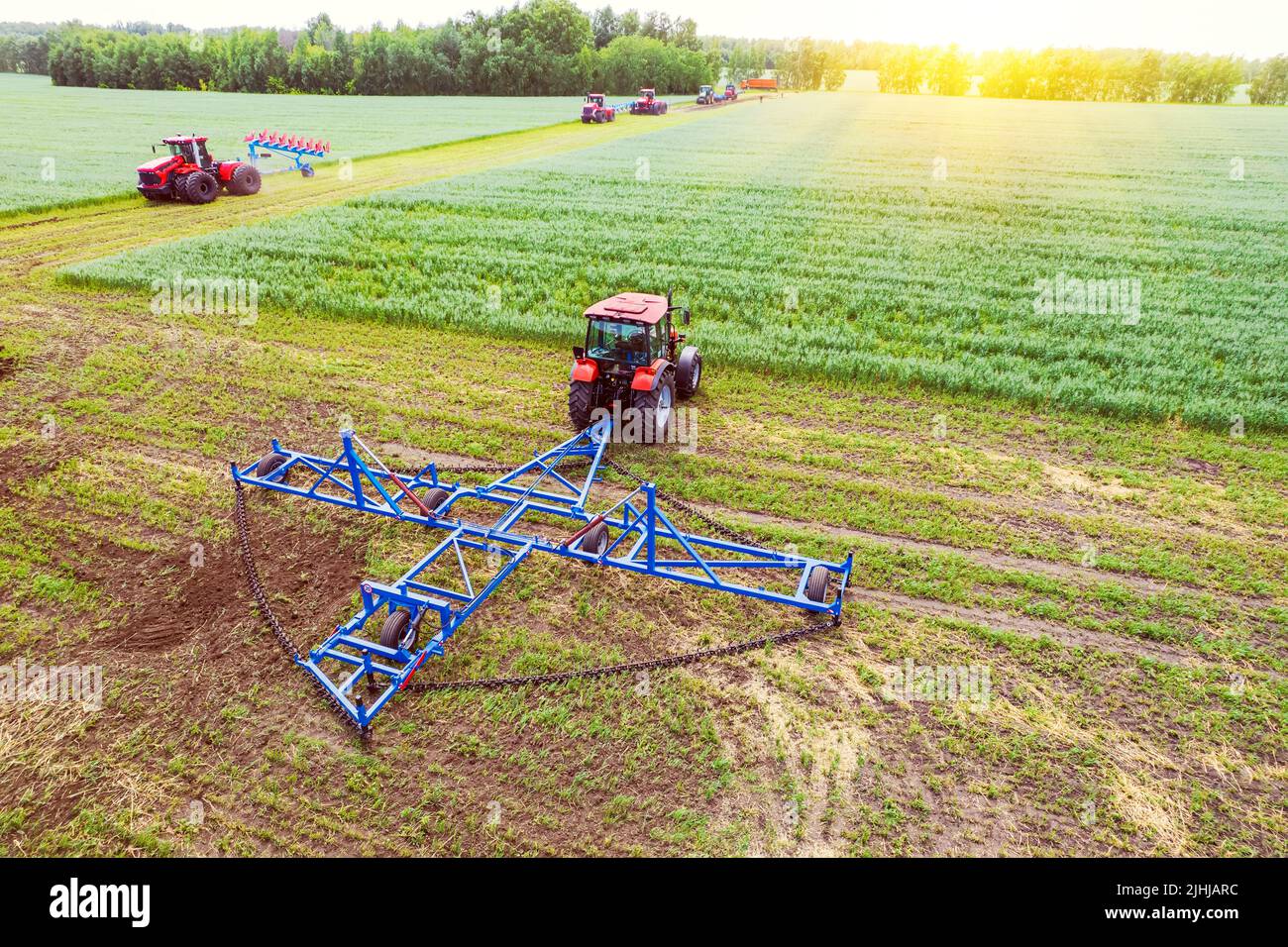 Machine agricole la récolte dans les champs. Le tracteur tire sur un mécanisme pour la fenaison. La récolte en automne le matin à l'aube. de l'agrobusiness en t Banque D'Images