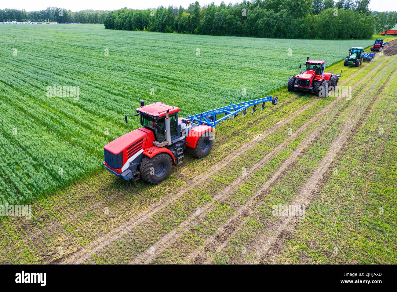 Tracteurs avec charrue sur le sol. Terrain de bowling du tracteur, vue de drone. Travail du sol et des plantes cultivées. Tracteurs agricoles sur cultivati Banque D'Images