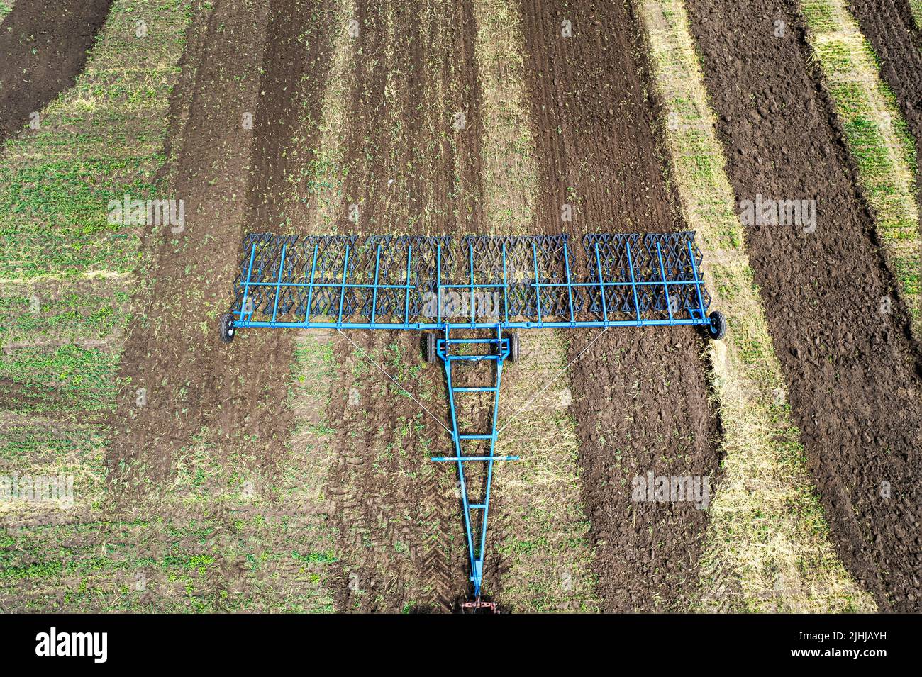 Machine agricole la récolte dans les champs. Le tracteur tire sur un mécanisme pour la fenaison. La récolte en automne le matin à l'aube. de l'agrobusiness en t Banque D'Images