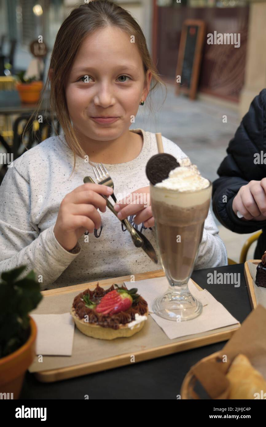 une fille avec un milkshake et un gâteau Banque D'Images